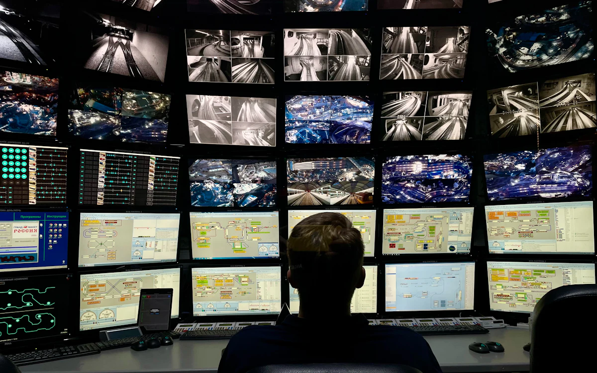 Analyst watching a wall of monitoring screens.